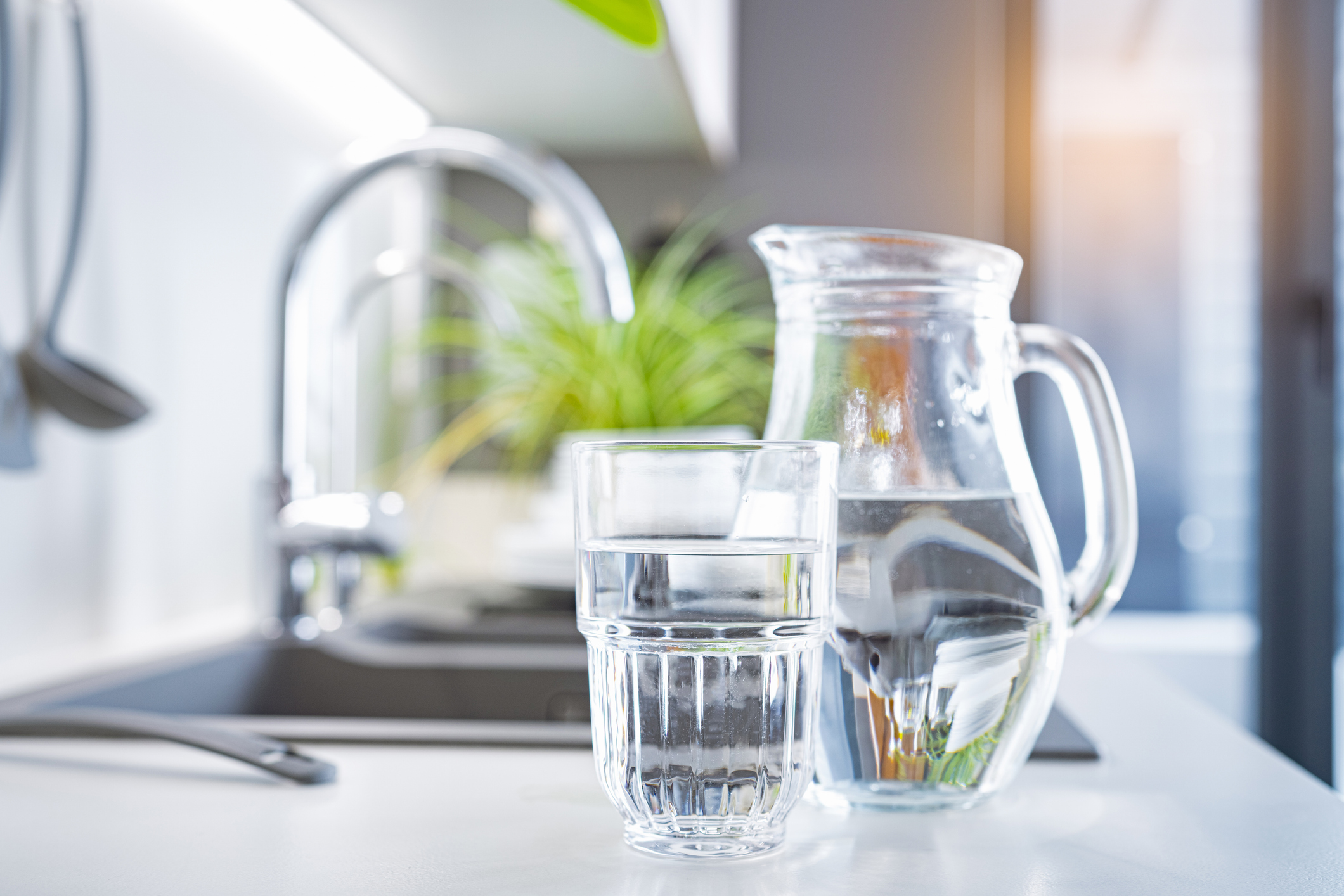 Close up of a glass of water and a jug on kitchen counter. High resolution 42Mp indoors digital capture taken with SONY A7rII and Zeiss Batis 40mm F2.0 CF lens