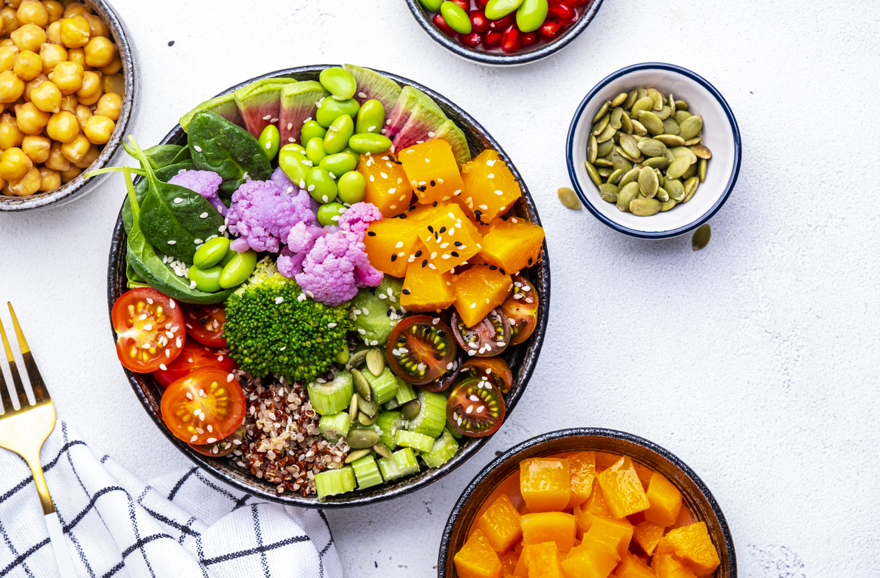 Vegan buddha bowl for balanced diet with sweet potato, quinoa, tomatoes, spinach, celery, edamame, tofu, broccoli and seeds, white background, top view
